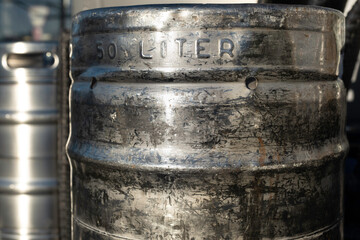 Large damaged metal beer barrels with the text '50 liter'