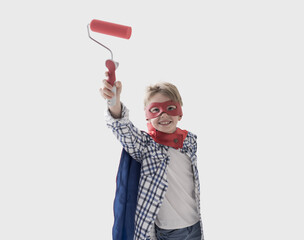 Cute superhero boy holding a paint roller