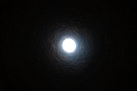 The light at the end of the tunnel concept. The old deep abandoned well. Inside view.