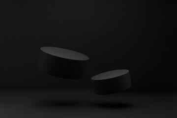 Two inclined black round podiums levitate, mockup on black background, shadow. Template for...