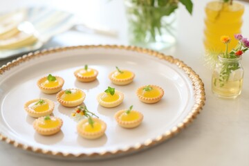 Obraz na płótnie Canvas tiny lemon tarts on a platter for party serving