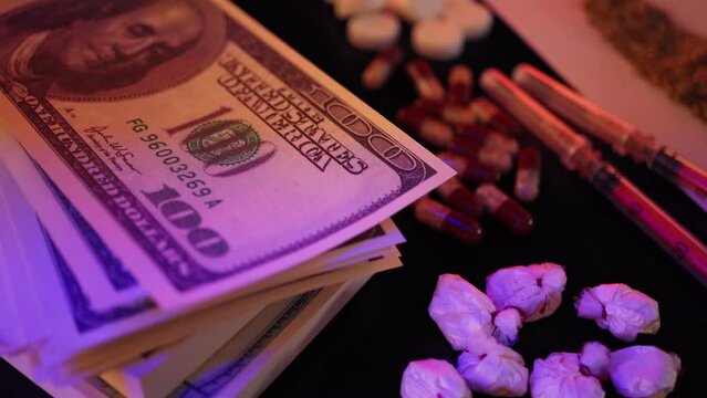 Close-up of drugs and money. Human addiction. Harm to health and violation of the law.