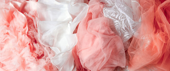 Top view abstract background of crumpled pink and white chiffon.