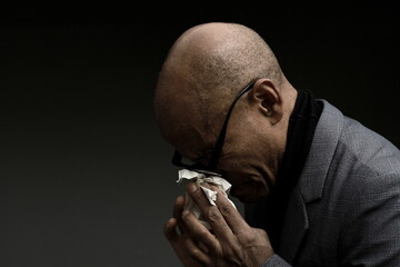 cold and flu blowing nose after catching the flu with grey black background with people stock image...