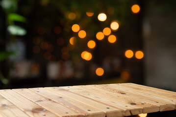 Empty wooden table in front of blurred cafe bar or restaurant. Abstract lights bokeh background,...