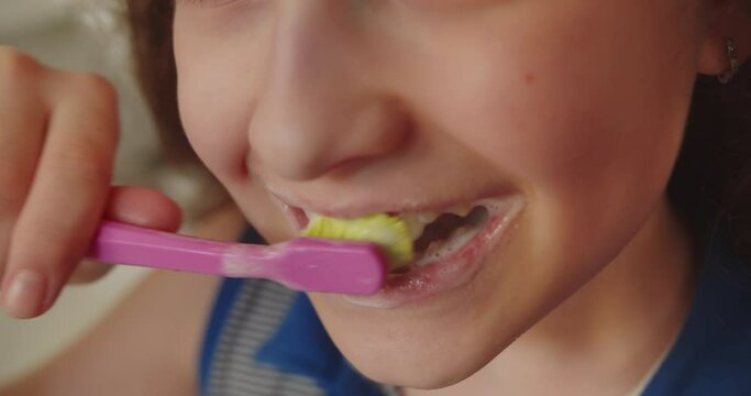 Close up of mouth brushing teeth with wellness, oral hygiene and cleaning in a bathroom, growth or care. Child brushing his teeth. Portrait happy cute young girl brushing teeth in bathroom and smiling