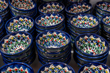 Bukhara. Uzbekistan. Shopping place. Ceramic cups and bowls decorated by traditional uzbek patterns. Blue pattern. Unfocused. - obrazy, fototapety, plakaty