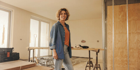 Happy female homeowner smiling during a DIY kitchen renovation