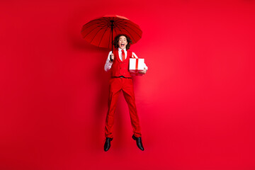 Full length photo of boy partner in relationship boyfriend flying with parasol wear retro clothes bring gift box over red color background