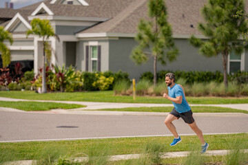 Fit man fitness model workout outdoor. Man runner on the street running for exercise. Man running in at spring morning. Running man. Male runner jogging. Guy training outdoors. Sport, cardio concept.
