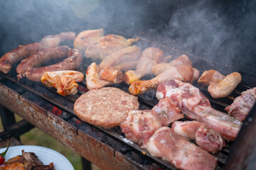 Assorted delicious grilled meat with vegetables over the coals on a barbecue