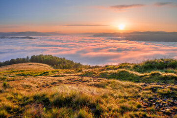 Picturesque sunrise over a sea of morning mist in the mountains. Carpathians, Ukraine