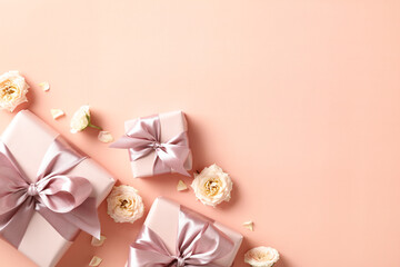Flat lay composition with gift boxes, roses buds on pastel beige background. Valentines Day, love, romance concept
