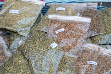 Medicinal, aromatic and cooking herbs for sale in transparent plastic bags in a traditional market. Rosemary, thyme, anise, cumin and bay leaf