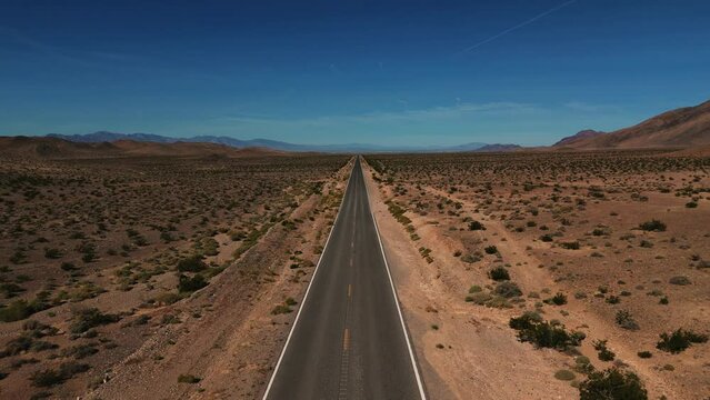 Desert highway in Nevada. Empty street road from above in the dry hot Wild West America landscape. Aerial drone