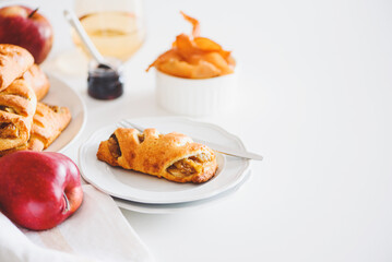 Apple cinnamon pastry rolls on white wooden table