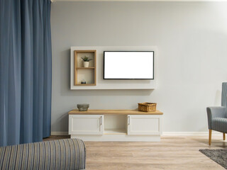 TV screen template in a living room. Blank display mockup with a white box as copy space. The television is hanging on the wall. The decoration in the domestic environment is sparse. 