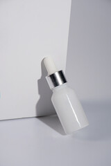 Plastic white tube for cream or lotion. Skin care or sunscreen cosmetic with stylish props on white background 