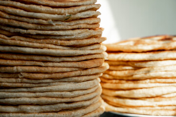 Flatbread lavash, chapati, naan, heap of tortilla on a blue background Homemade flatbread stacked.