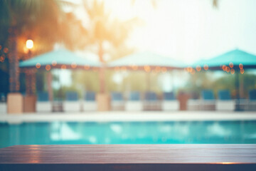 Wooden table pool bokeh background, empty wood desk product display mockup with blurry tropical hotel resort abstract poolside summer travel backdrop advertising presentation. Mock up, copy space.
