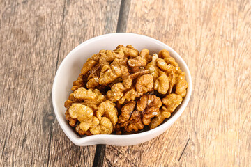 Cracked unshelled walnut in the bowl
