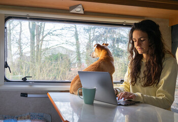 Woman working remotely from a motor home with her dog