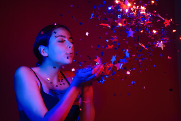 Sexy girl blowing confetti. Portrait of beautiful young woman on birthday valentines day. Sexy girl blow sparkles on birthday. Sensual woman celebrating birthday. Happy valentines day. Birthday party.