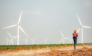 Engineer working in wind turbine farm with blue sky background