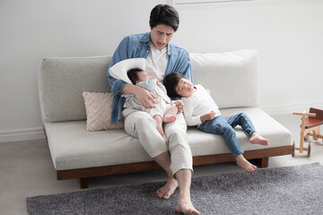Young father on holiday taking care of (and raising) his siblings in the living room. Go for it! Dad
