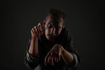 Scary zombie on dark background. Halloween monster