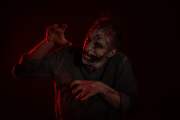 Scary zombie on dark background. Halloween monster