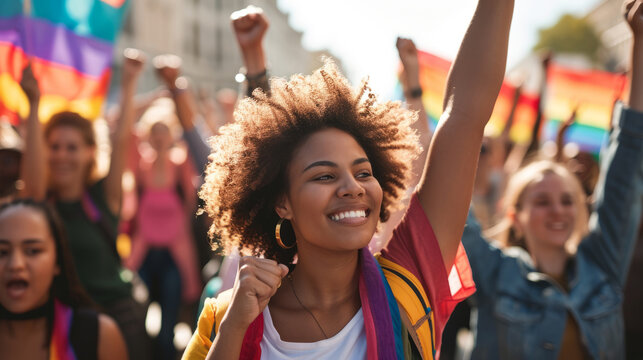 LGBT Woman Marching In Protest With A Group Of Protestors With Their Fist Raised In The Air As A Sign Of Unity For Diversity And Inclusion.