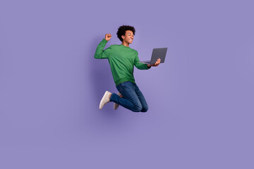 Fototapeta na wymiar Full length photo of funky lucky guy wear green pullover winning apple samsung gadget jumping high isolated purple color background