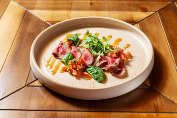Roast beef with arugula. On a wooden table.
