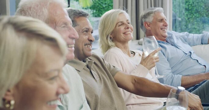 Mature group of people watching tv with drink, smile and bonding together in living room to relax. Friends, senior men and happy women on couch with wine, retirement and comedy on television in home.