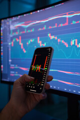 Crypto trader investor broker holding finger using cell phone app executing financial stock trade...