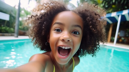 Happy little African American girl taking selfie in an outdoor swimming pool