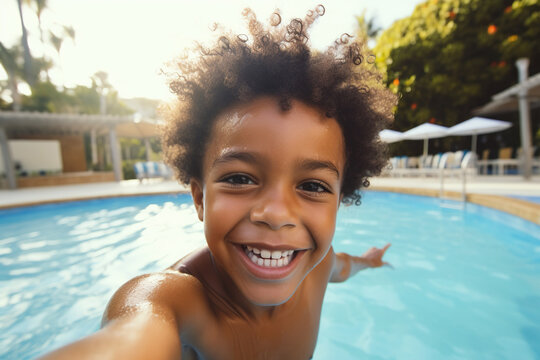 Happy little African American boy taking selfie in an outdoor swimming pool