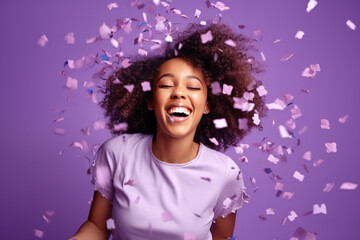 Energetic active African American lady dancing moving on holiday with flying confetti isolated on violet color background