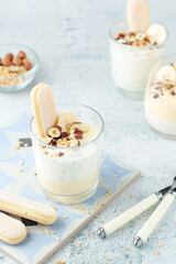 Milk mousse dessert with nuts in glasses