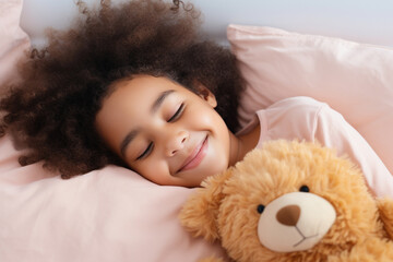 Top view of cute little preschooler African American girl lying cuddling with favorite fluffy toy waking up in cozy home bed