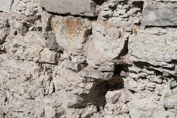 Structural background from a fortress wall made of natural stone.