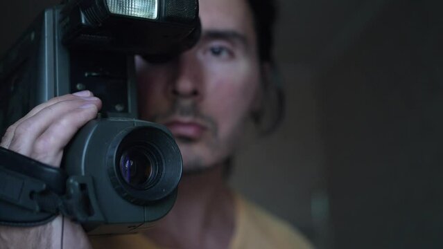 A handsome cameraman with a retro camcorder, man with camera. Slow motion