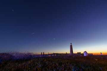 Cross on a stone pillar at Cabo da Roca under the night sky with planets Venus, Saturn and Jupiter...