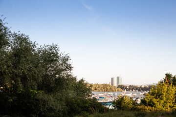 Panorama of boats anchored on the sava river by the veliko ratno ostrvo island with the Usce towers, Usce 1 and 2 in New Belgrade. in background These are a mixed used business high rise skyscraper.