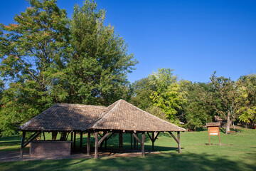 Fototapeta na wymiar Panorama of the main clearing of Devojacki bunar with its iconic Wooden well in summer. Devojacki Bunar is a touristic settlement of Vojvodina, in Serbia.