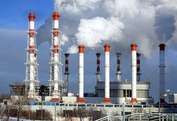 Thermoelectric power station building with many high red and white industrial pipes with dense...
