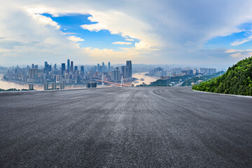 Asphalt road and city skyline with mountains nature scenery