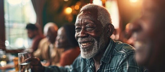 Happy African American senior man talking to his friends while eating at dining table at nursing home. Copy space image. Place for adding text