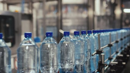 No people side fast motion of production line of mineral purified bottled water moving on conveyor belt at drinking water plant